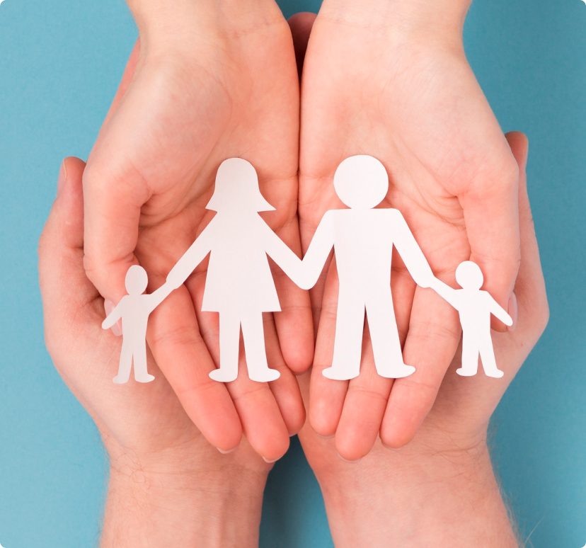 Imagen de unas manos, sosteniendo una figura de papel de una familia